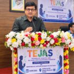 Sansar Green MD Rajeev Singh speaking at a flower-decorated podium during the TEJAS programme in Giridih on 29 September 2026.